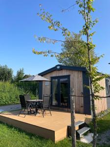 a small cabin with a table and chairs on a deck at Naab Chalet 11 in Nabburg