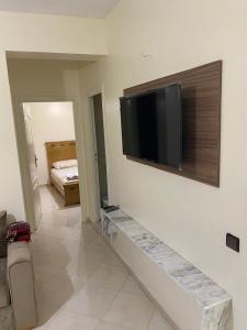 Una sala de estar con un televisor de pantalla plana en una pared. en Gzenaya, en Tánger