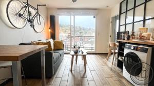 a living room with a couch and a bike hanging on the wall at Au Petit Vélo - Appart Vue sur la Bâtie - Parking Gratuit & Calme - Vienne in Vienne