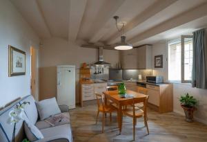 ein Wohnzimmer mit Tisch und Küche in der Unterkunft Ferienwohnung Le Volte in der Residenza dei Piaceri Perduti in Lastra a Signa