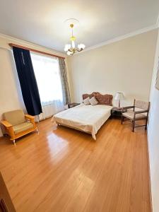 エレバンにあるApartment near Rio Mall with 2 bedroomsのベッドと椅子と窓のある寝室 +14枚の写真