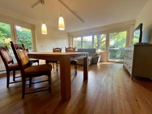 a living room with a wooden table and chairs at Ruhiges Ferienhaus direkt am Wald in Hechthausen
