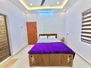 玛莱尤尔Maha Home Stay的卧室里有一张铺着紫色床单的大床