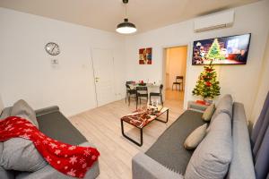 een woonkamer met een bank en een kerstboom bij Bucharest Christmas Decorated City Center Villa in Boekarest