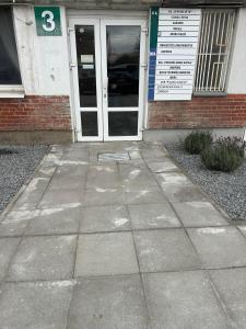 a sidewalk in front of a building with a door at Draugystės apartmentai in Kaunas