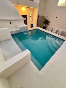 a swimming pool in the middle of a house at The Mermaid and The Pearl Boutique Hotel in Isla Mujeres