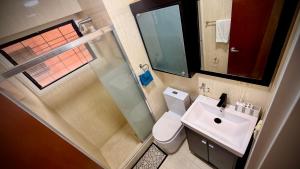 Un baño con inodoro, lavabo y ducha. en Apartamento en Campo Alegre, Chacao, Caracas, en Caracas