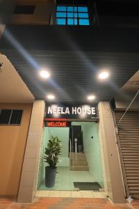 a welcome sign for a neela house in a building at Neela House in Labuan