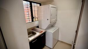 Una pequeña cocina con fregadero y refrigerador. en Apartamento en Campo Alegre, Chacao, Caracas, en Caracas 5 fotos más