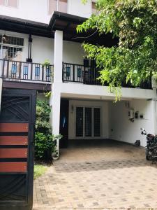 un grand bâtiment blanc avec un balcon et une allée. dans l'établissement The Triantha, 