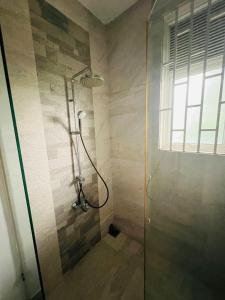 une douche avec une porte vitrée dans une salle de bain dans l'établissement The Triantha, 