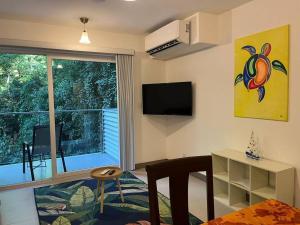 a living room with a large window and a television at Stunning 2 Bedroom Apartment in Punta Esmeralda , Costa Rica in Punta Leona