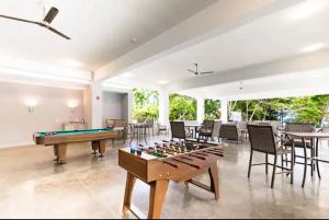 a living room with a pool table and chairs at Stunning 2 Bedroom Apartment in Punta Esmeralda , Costa Rica in Punta Leona