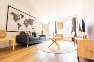 a living room with a couch and a map on the wall at T2 chic et confortable au centre d Epernay in Épernay