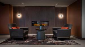 two chairs and a table in a room with a tv at Clayton Hotel Cardiff Lane in Dublin