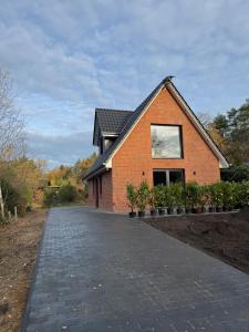 a brick house with a driveway in front of it at Lütte Lina in Neuenkirchen