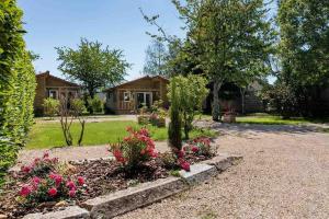 a house with a garden with flowers in the driveway at Lodge Natura in Ambérieu-en-Bugey