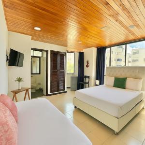 a bedroom with two beds and a large window at Las casas de tomate Cartagena in Cartagena de Indias