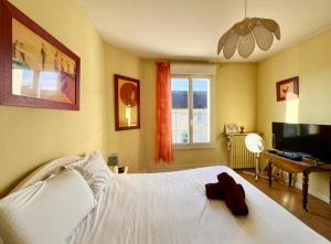 een slaapkamer met een wit bed en een flatscreen-tv bij Le Coquelicot - Centre - 8 Personnes - Parking in Le Mans
