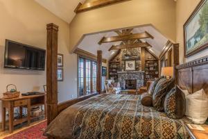 een slaapkamer met een groot bed en een open haard bij Elk Camp Lodge in Linville +51 foto's