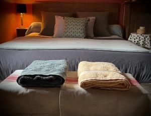 a bed with two towels sitting on top of it at B&B Le bain d'Alice in Saint-Laurent-sur-Gorre +44 photos
