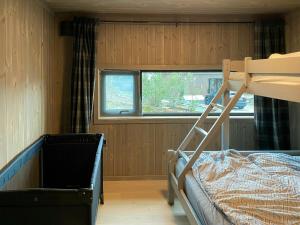 ein kleines Schlafzimmer mit einem Etagenbett und einem Fenster in der Unterkunft Modern Family Cabin By The Ski Trail In Tuddal in Tuddal
