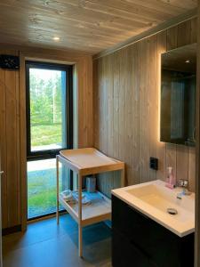 ein Badezimmer mit Waschbecken, Ablagefläche und Fenster in der Unterkunft Modern Family Cabin By The Ski Trail In Tuddal in Tuddal