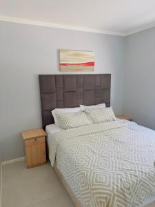 a bedroom with a bed and a painting on the wall at Blouberg Beach Gem 5 Min Walk in Cape Town