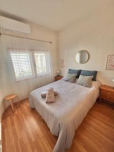 a bedroom with a large white bed and a window at Villa Banfield in Gran Alacant