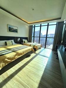a hotel room with two beds and a large window at La Maison in Cat Ba +30 photos