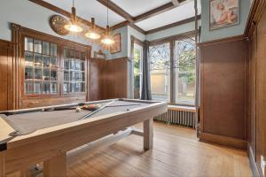 a ping pong table in a room with a pool table at Heritage House Downtown Moncton in Moncton