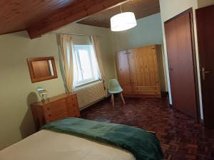 a bedroom with a bed and a chair and a window at Casa Gina in Roana