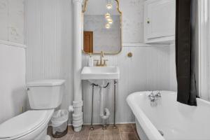 a bathroom with a toilet and a sink and a tub at Heritage House Downtown Moncton in Moncton +65 photos