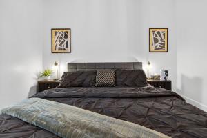 a large bed in a bedroom with two pictures on the wall at Heritage House Downtown Moncton in Moncton