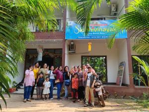 een groep mensen die voor een gebouw staan bij Konkan Paradise-Siddhivinayak,Devbag Beach Resort in Malvan
