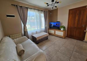 a living room with a couch and a tv at CasaDelSUr in San Carlos de Bariloche