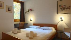 un dormitorio con una cama con sábanas y almohadas blancas en Hostdomus - Design Suite R10, en San Sicario