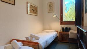 Una pequeña habitación con una cama y una ventana. en Hostdomus - Design Suite R10, en San Sicario