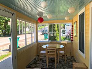 eine abgeschirmte Veranda mit einem Tisch und Stühlen in der Unterkunft UP Cottage in Saint Ignace