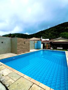 a large blue swimming pool on top of a house at Casa na praia do Guaiuba in Guarujá