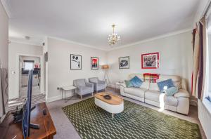a living room with a couch and a table at Nancy's 3 bedroom house near Heathrow Airport in Hounslow