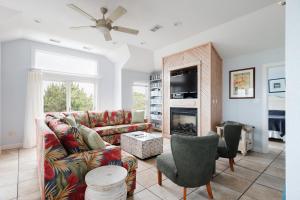 DolphinInnOBX في Southern Shores: غرفة معيشة مع أريكة ومدفأة