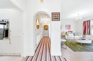 a white living room with a red and white striped rug at Nancy's 3 bedroom house near Heathrow Airport in Hounslow