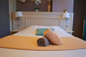 une chambre avec un lit avec une serviette dessus dans l'établissement La Pause Voyage - chambre privative, gare à proximité, à Bourbourg