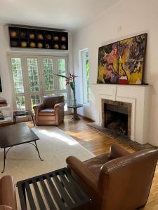 un salon avec un canapé et une cheminée dans l'établissement Charmosa casa 4 suítes no Jd Europa, à São Paulo