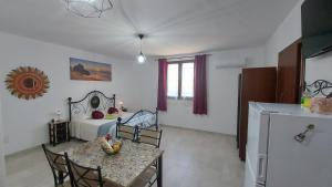 PerdaxiusにあるCasa Vacanza Da Gabryのテーブルとベッド1台付きの部屋、キッチンが備わるアパートメントです。