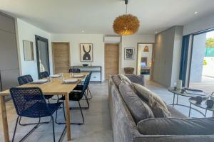 Un comedor y una sala de estar con mesa y sillas. en Villa Arinella Villata Di Capicciola, en Sainte-Lucie de Porto-Vecchio