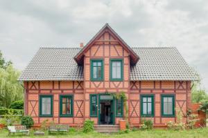 a red house with black windows and a gray roof at Idyllic Home Between Fields And Elbe Dyke in Seehausen