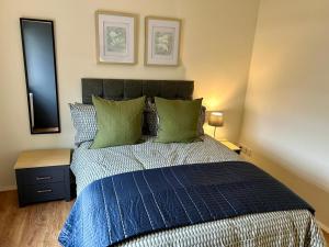 ein Schlafzimmer mit einem blauen Bett und grünen Kissen in der Unterkunft Apartment next to The Oxford Union in Oxford + 8 Fotos