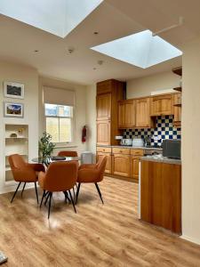 eine Küche mit Holzschränken und einem Tisch und Stühlen in der Unterkunft Apartment next to The Oxford Union in Oxford